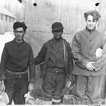 three men standing in front of building