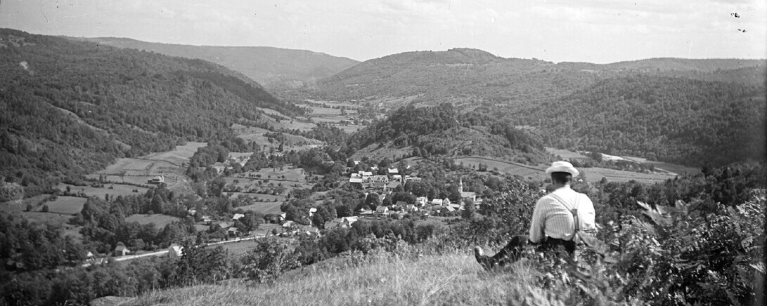 Man sitting on hill overlooking Townsend, Vermont