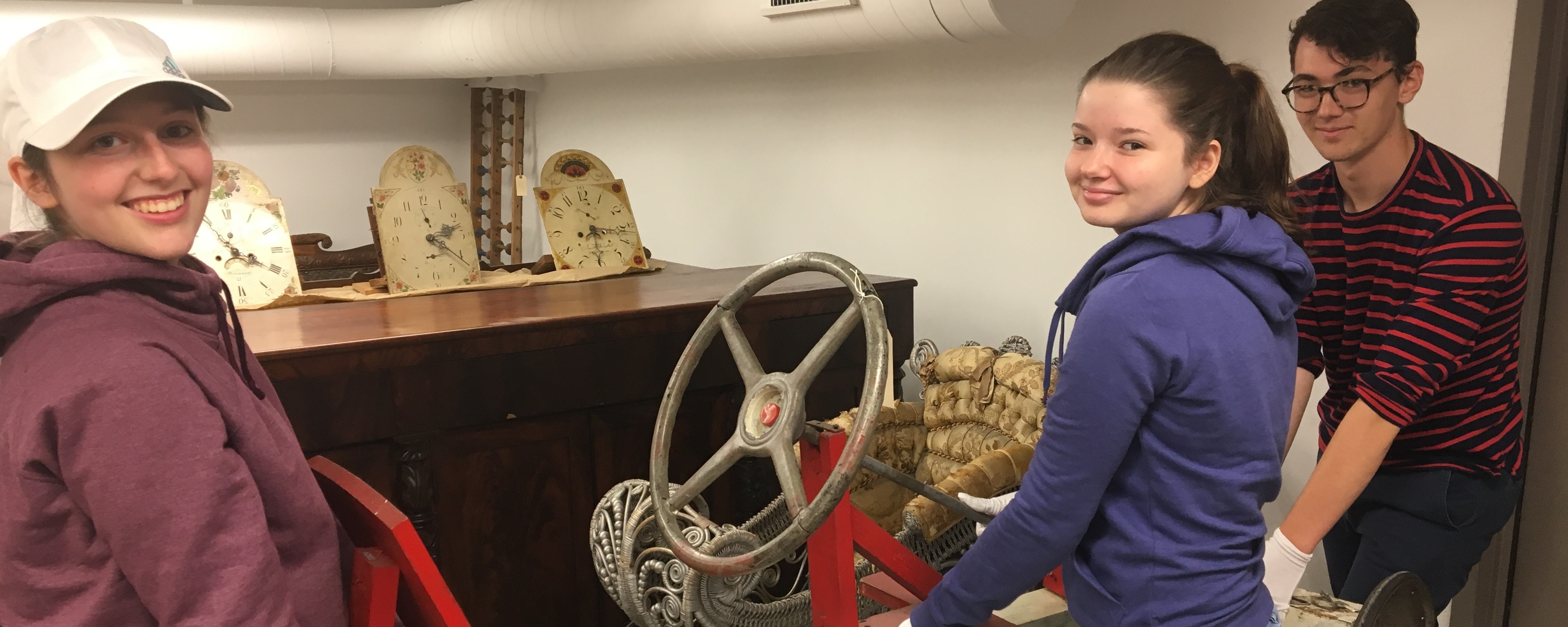 three students holding pedal car