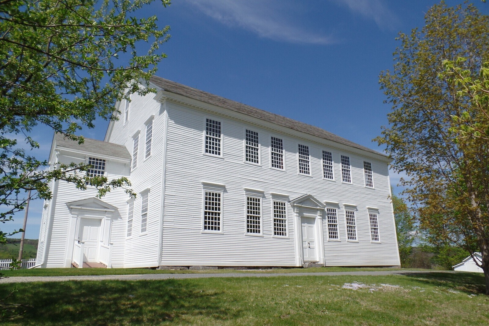 large white building with many windows flanked by trees