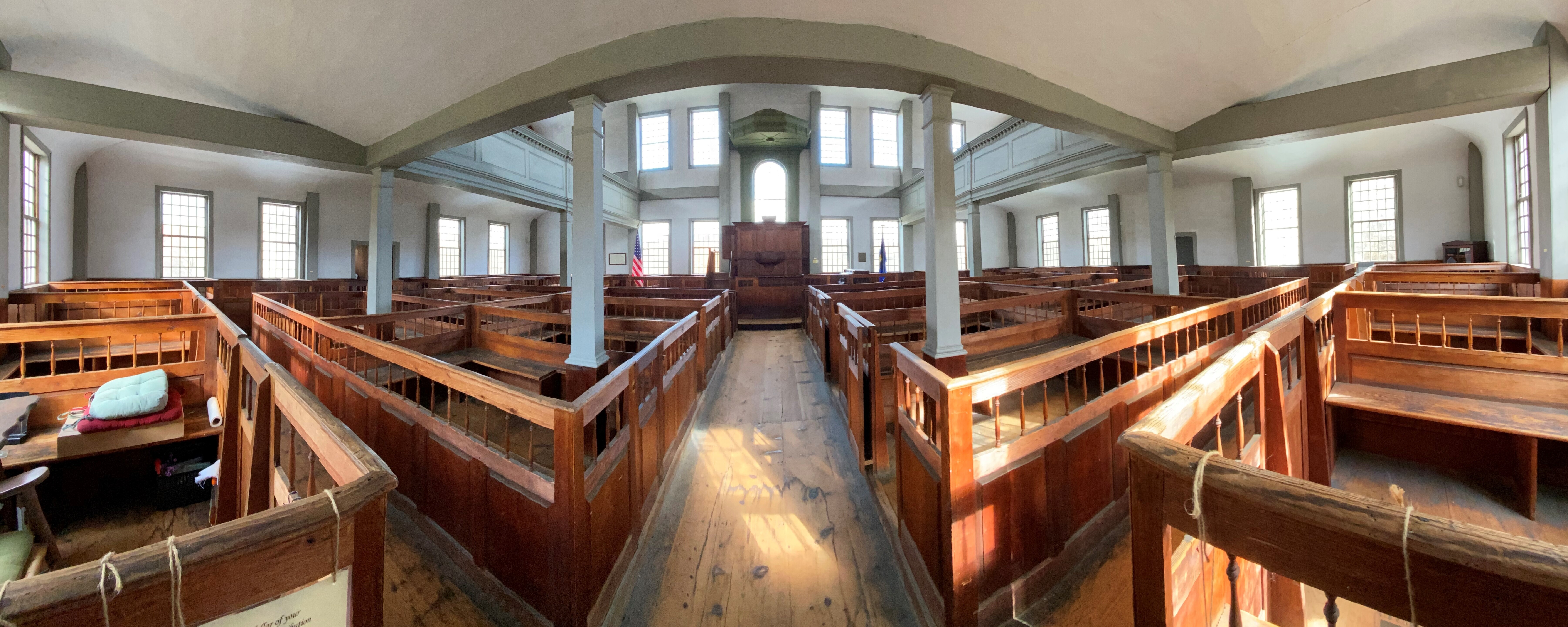 interior of historic building featuring many box pews