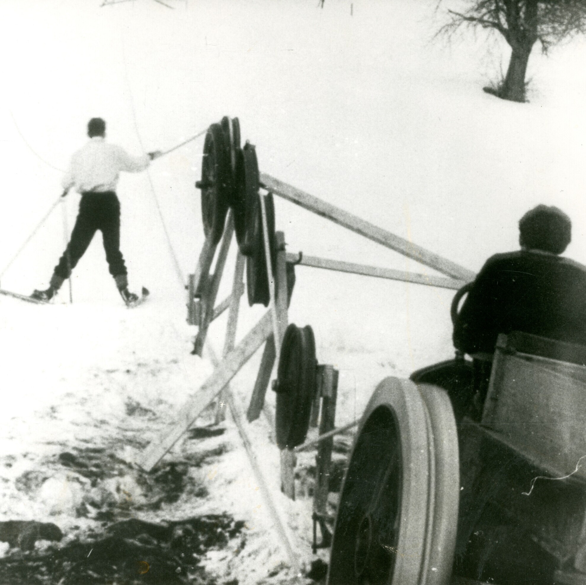 man using rope tow to get up ski hill