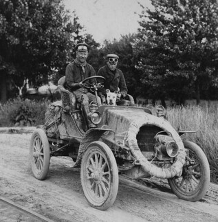 old photo of two men in car with dog