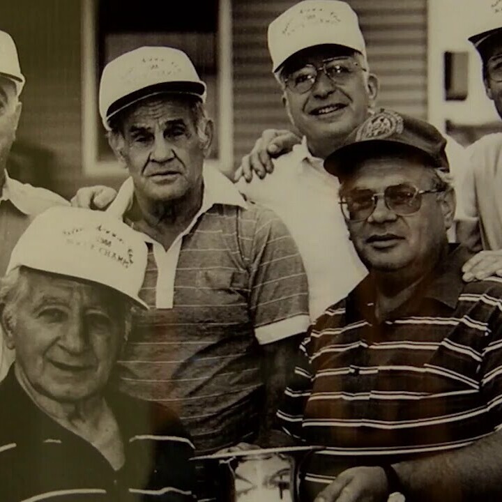 four men in hats holding trophy